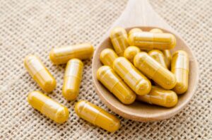 herbal capsule. alternative medical care on sack background.